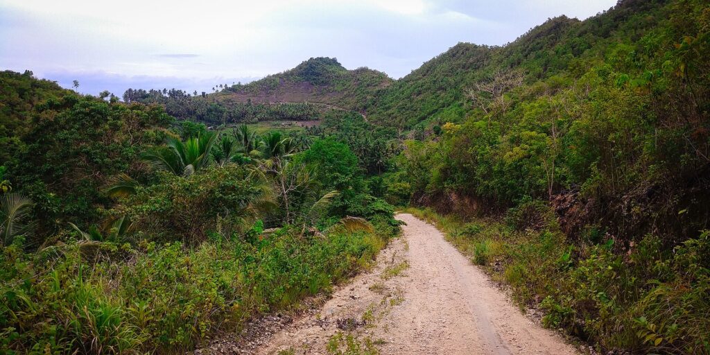 Dirt road through green hills on the way to the canyon start