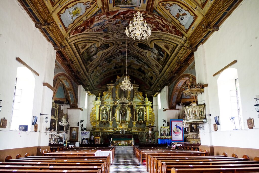 Painted wooden ceiling and gilded retablo inside Argao Church