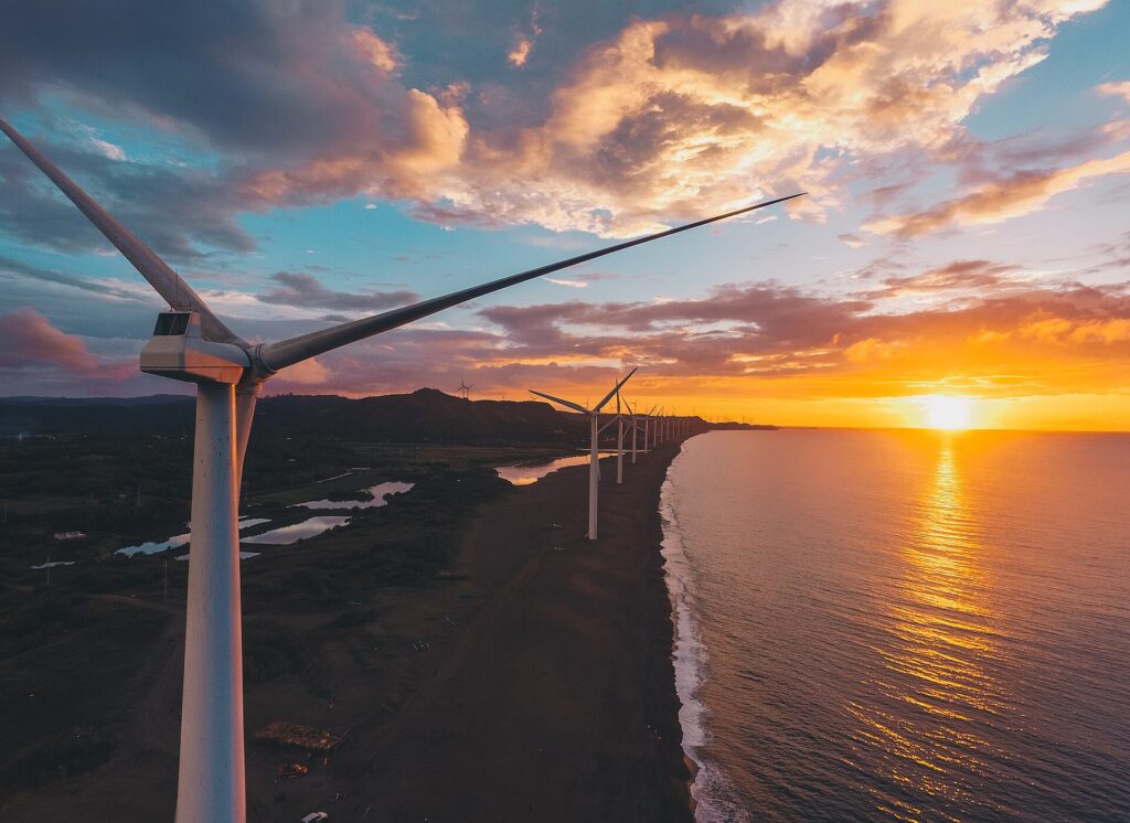 Sunset over the coastline and wind turbines, seen from the air