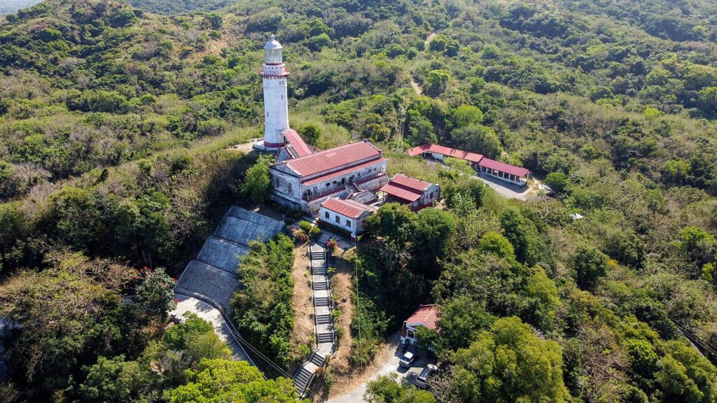 The 1892 Cape Bojeador Lighthouse on its forested hill above Burgos