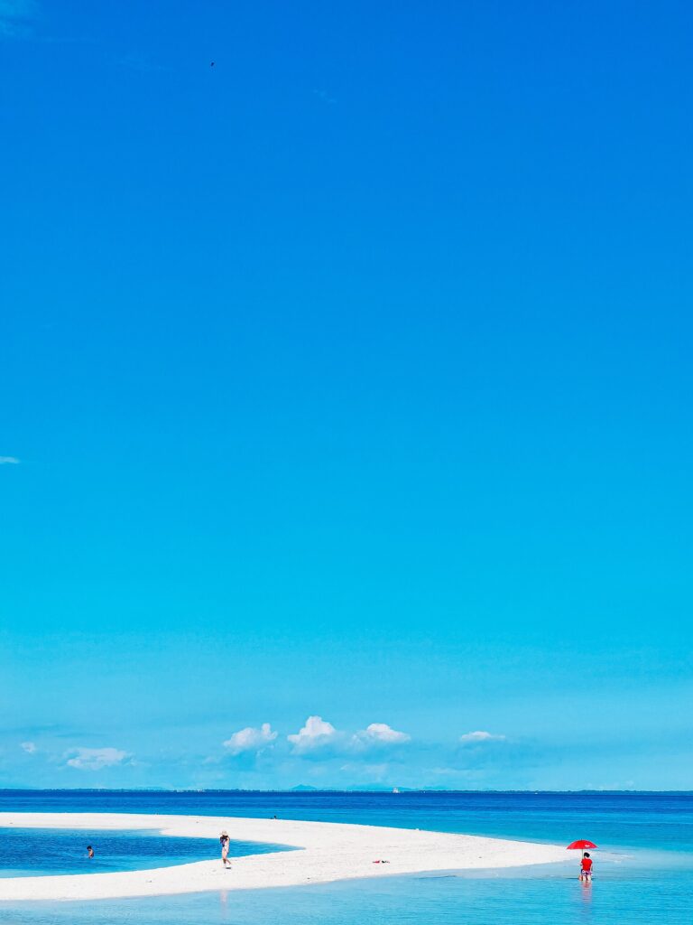 The long white Kota sandbar in clear shallow water