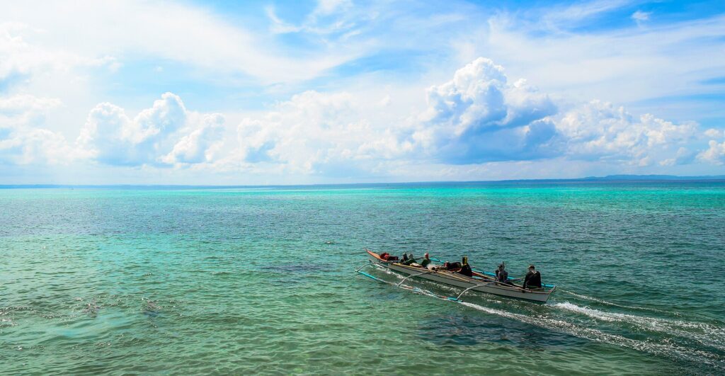 Fishermen heading out over turquoise water near Bantayan