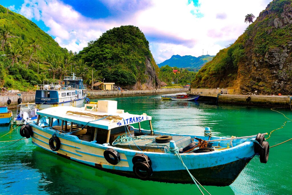 A brightly painted boat in a sheltered cove near Basco