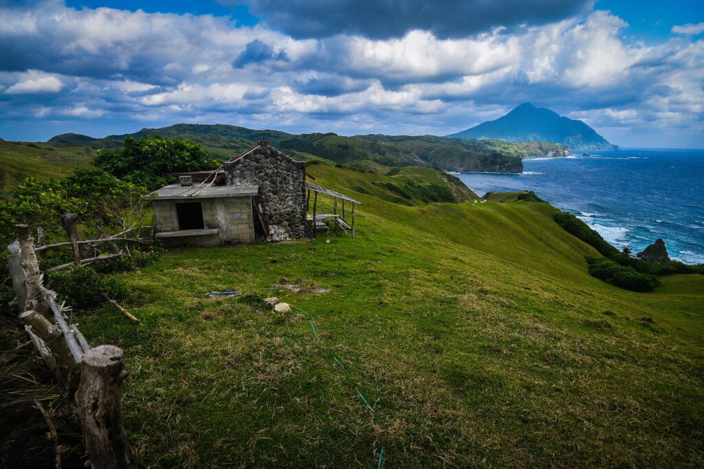 A small stone hut on a grassy headland above the sea