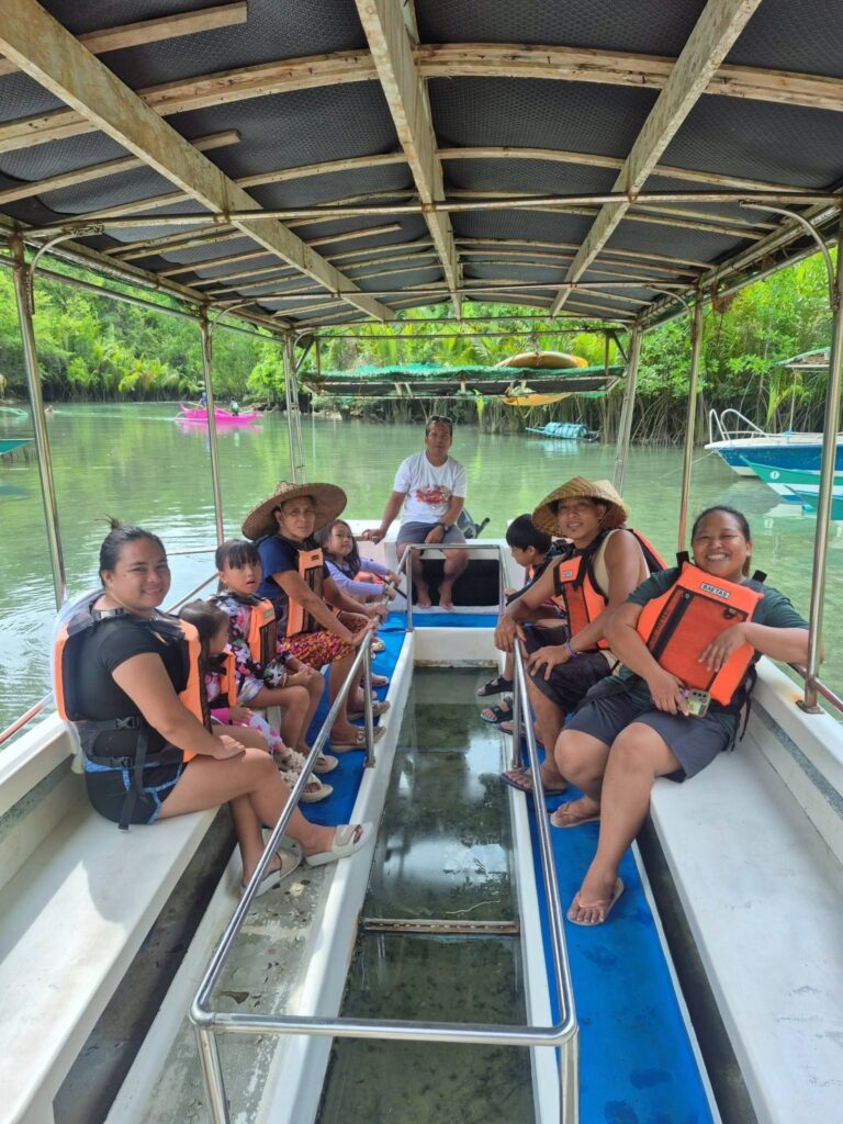 A family in life vests on a Bojo River tour boat with a clear panel in the floor