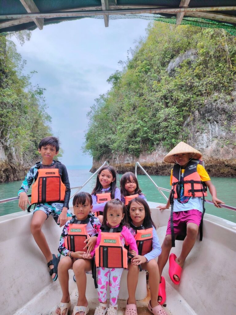 Children in life vests sitting on the bow of the tour boat