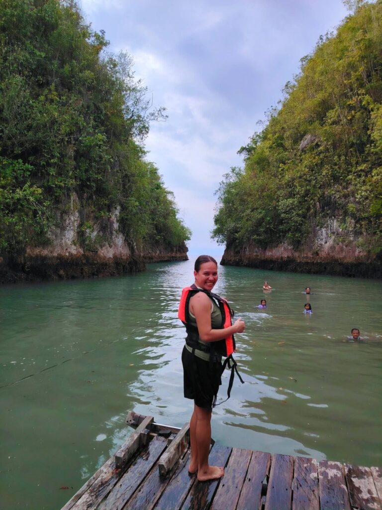 A visitor in a life vest on the jetty above clear green water