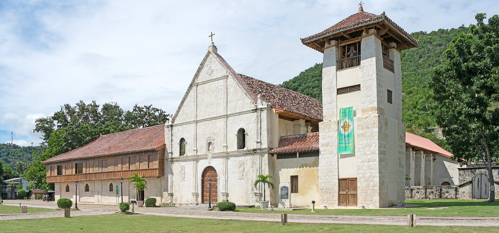 Patrocinio de Maria Church in Boljoon with its bell tower, old convent and green hills behind