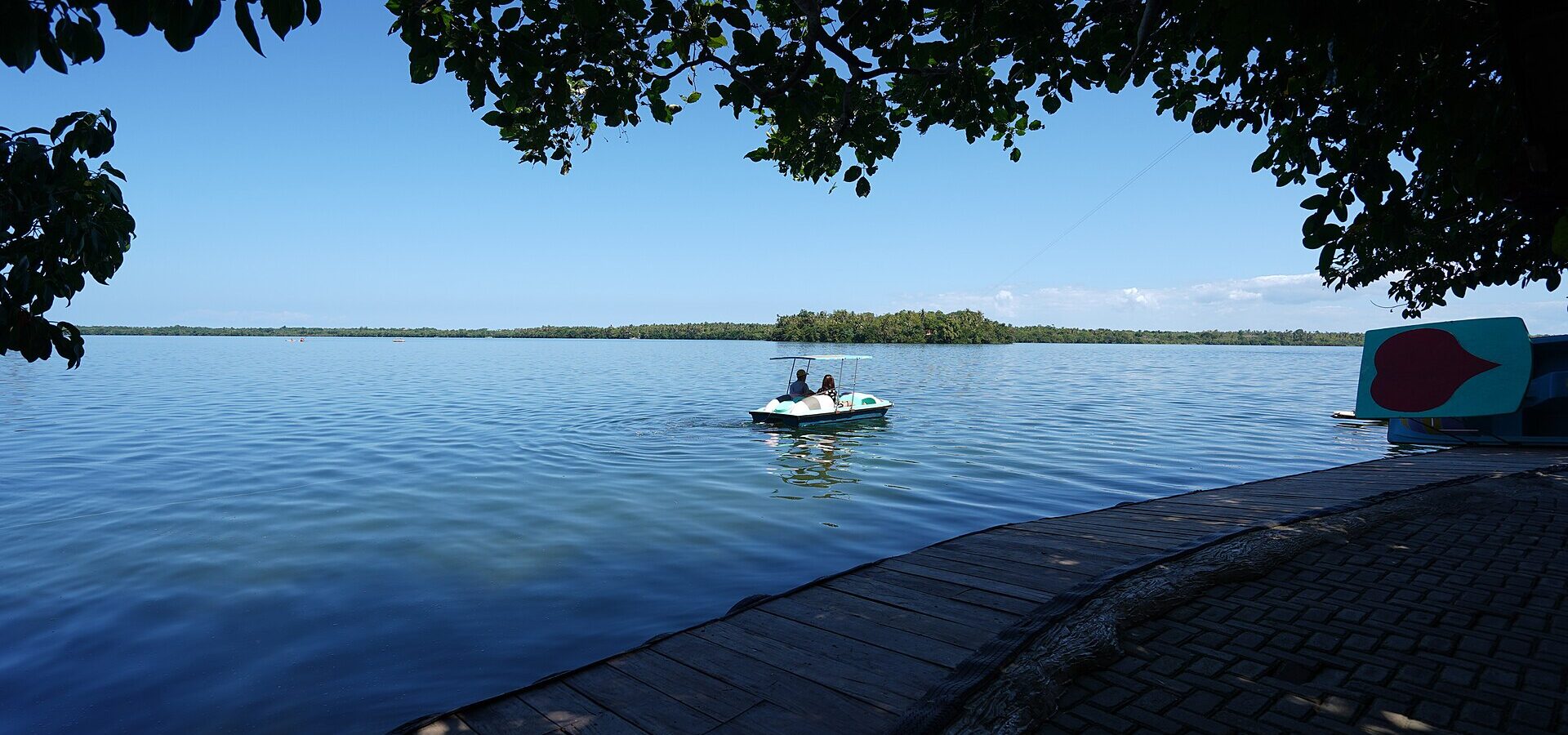 Lake Danao in San Francisco, Camotes, seen from the lakeside boardwalk with a pedal boat on calm blue water