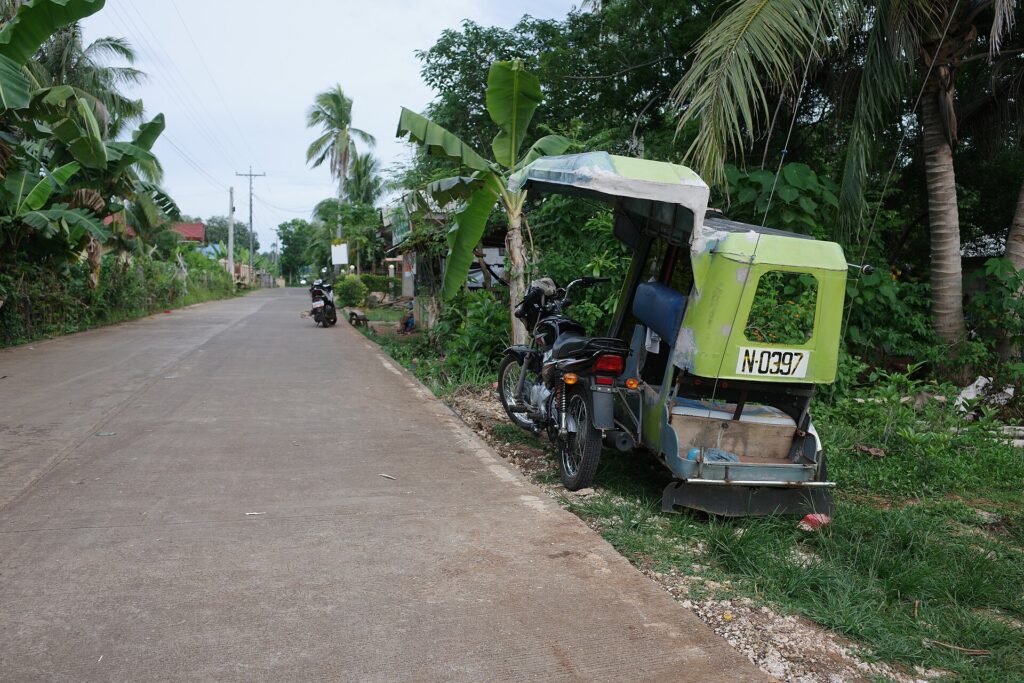 A tricycle on a quiet country road on Pacijan Island