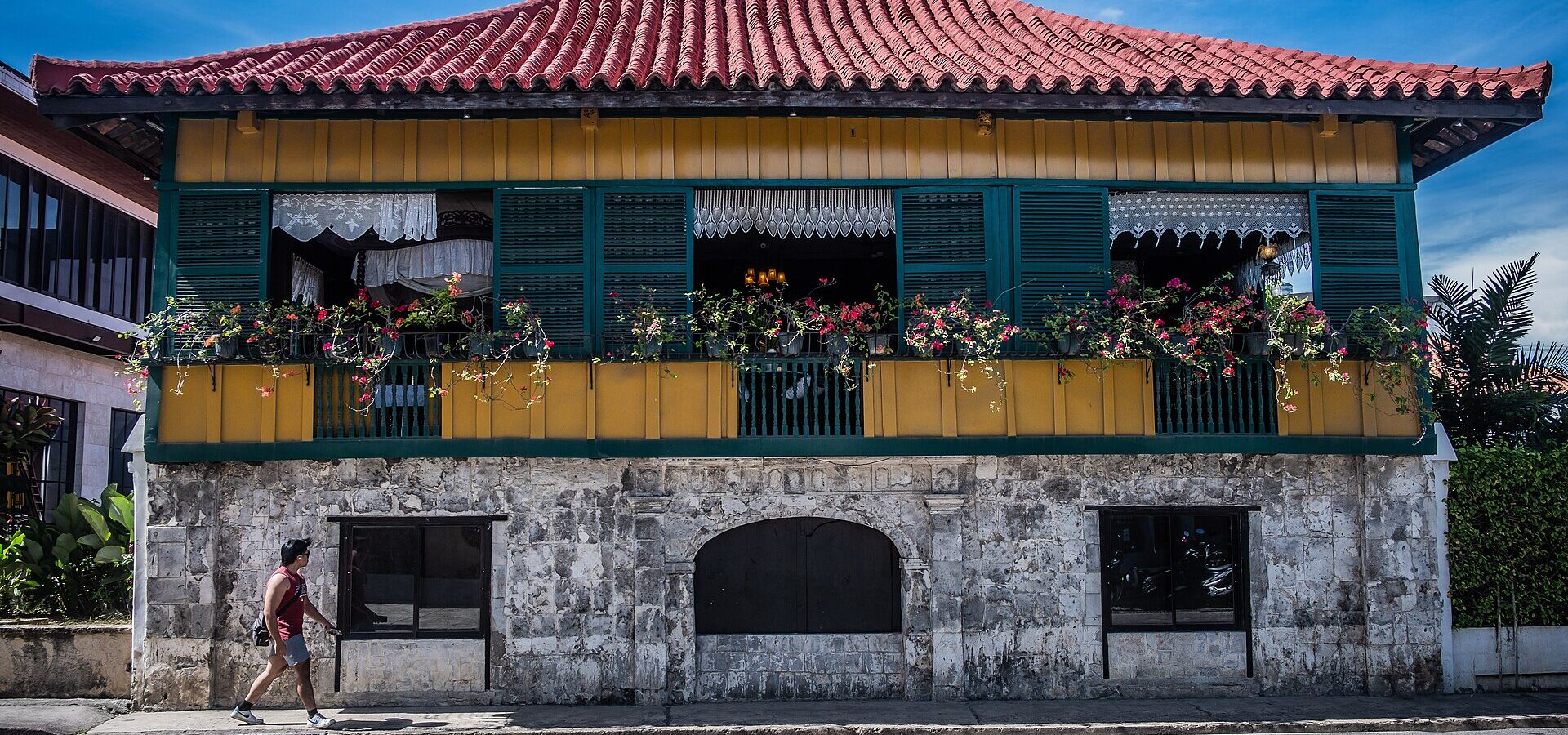 The red-tiled two-storey Casa Gorordo with its stone ground floor and flower boxes on the upper windows