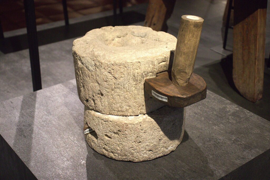 An old stone grinder and wooden pestle from the ground-floor exhibit