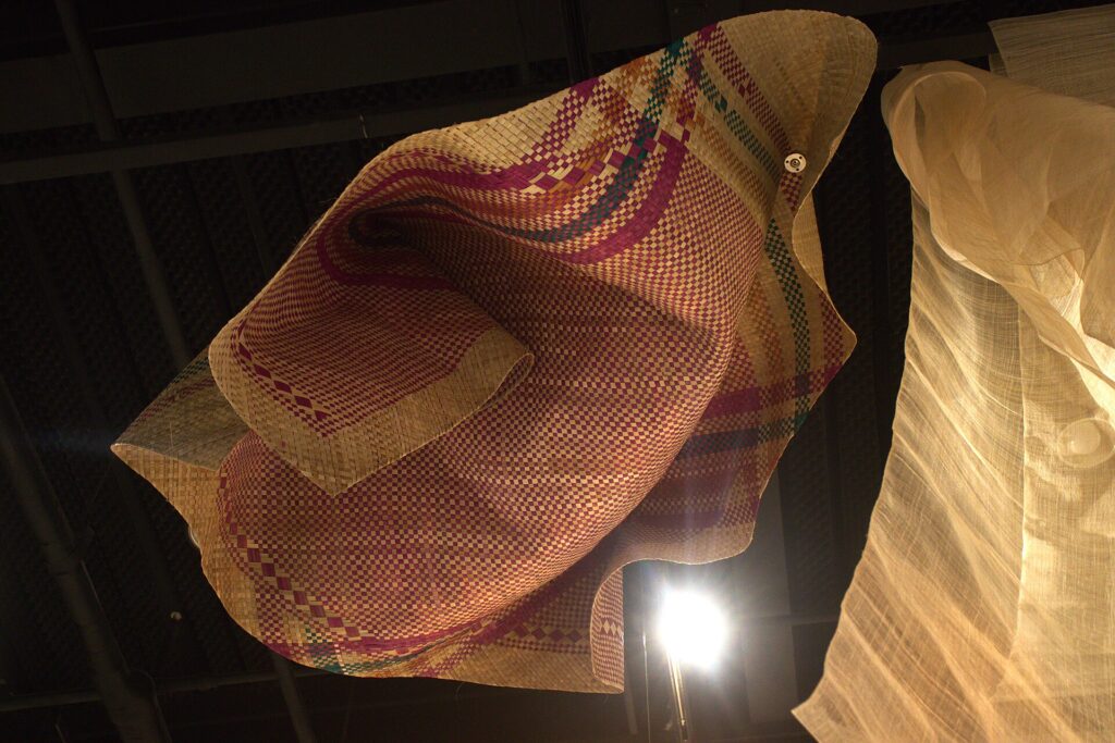 Hanging woven pieces lit in the museum