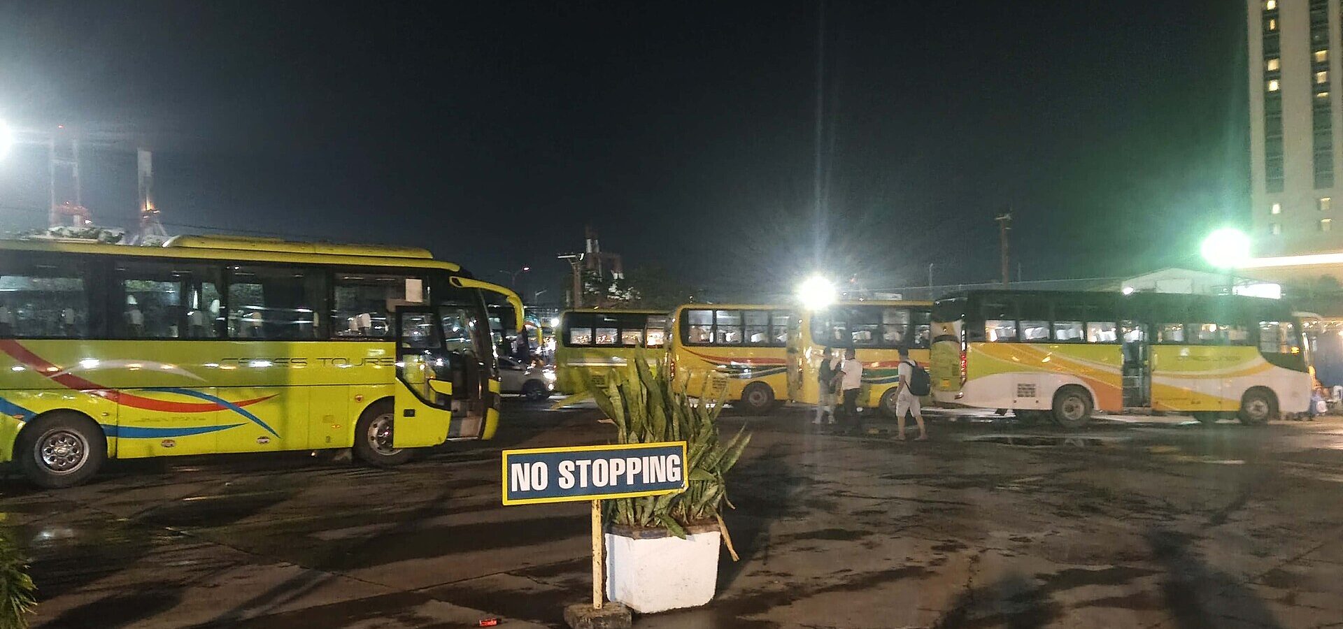 Yellow provincial buses waiting at the Cebu North Bus Terminal beside SM City Cebu in the evening, 2026