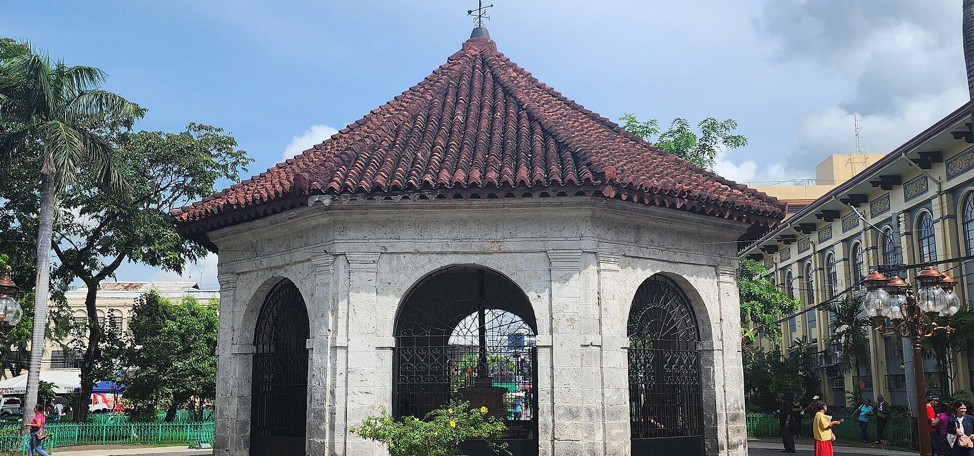 The stone kiosk of Magellan's Cross on Plaza Sugbo, Cebu City, under a blue sky