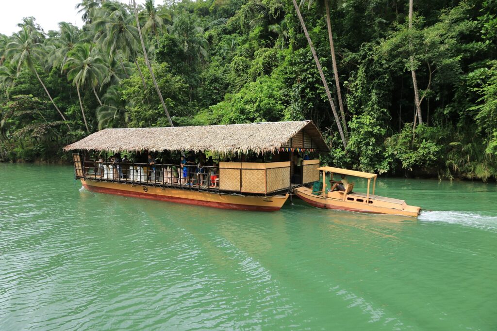 A floating restaurant raft drifting down the green Loboc River