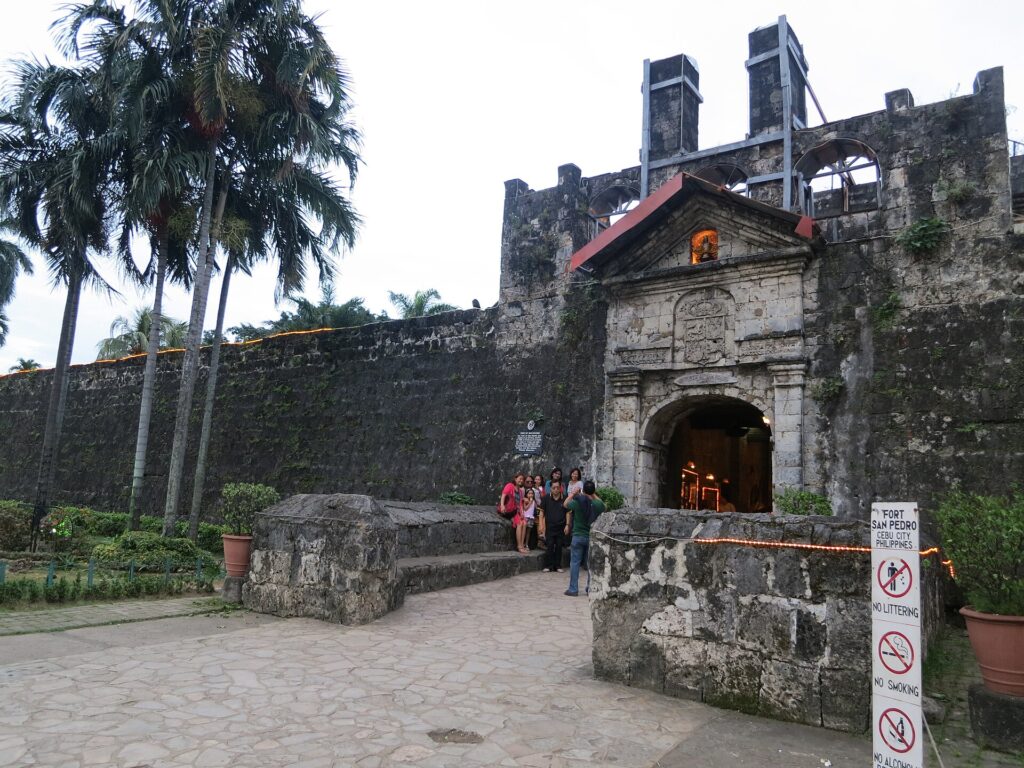 The gate and old wall seen from the side, with visitors outside