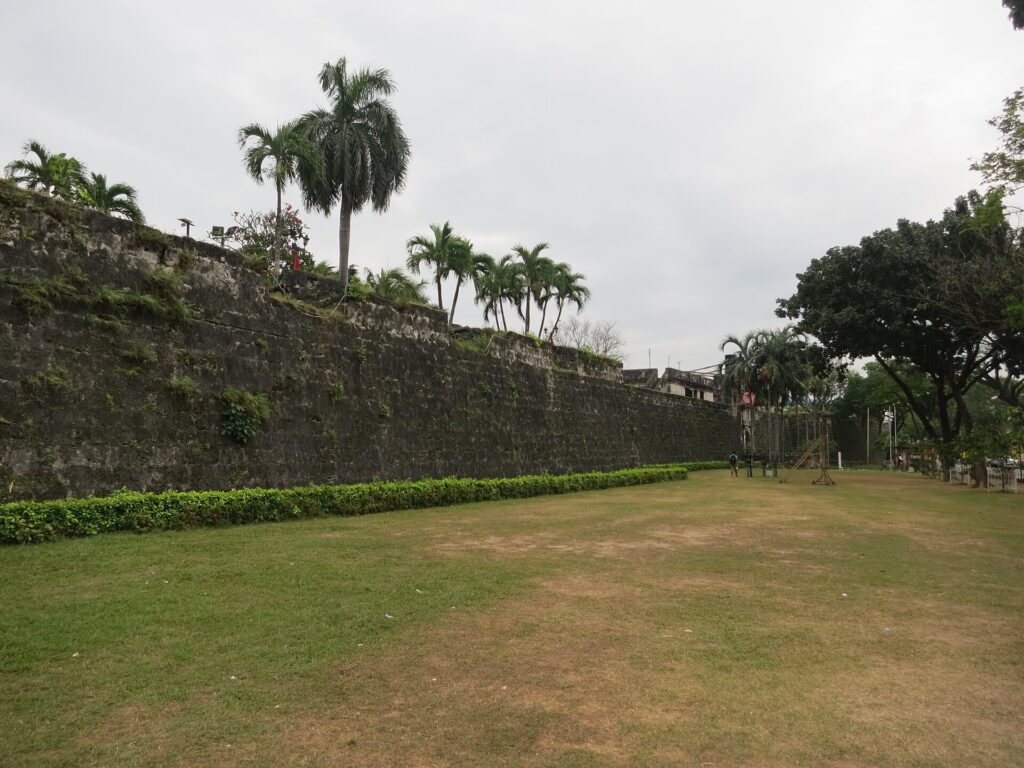 The thick coral-stone western wall seen from the lawn outside