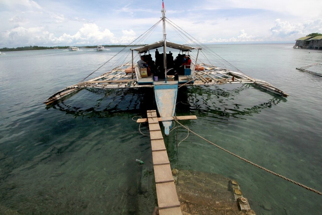 A bangka at a wooden jetty on neighbouring Olango Island