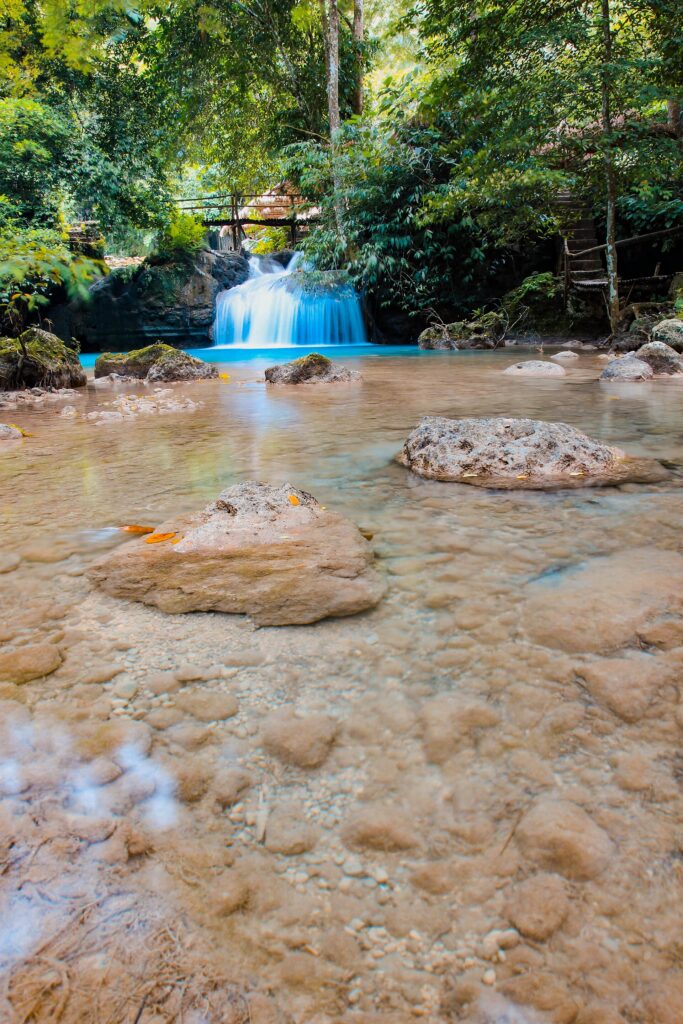 Clear water over smooth rocks on a bend of the Kawasan River