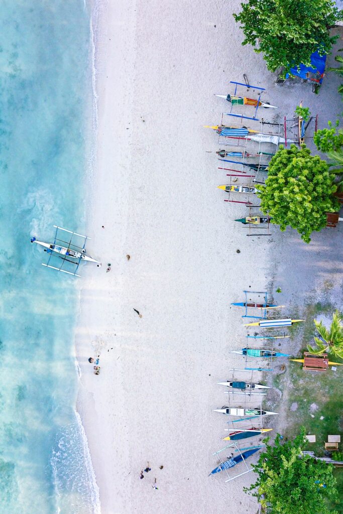 Aerial view of Lambug's white sand, clear water and bangka boats
