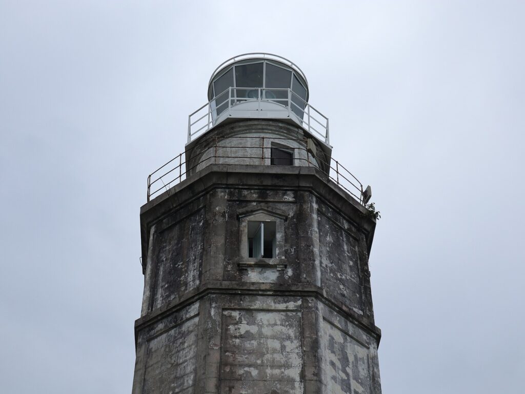 The stone tower and lantern of Bagacay Point Lighthouse up close