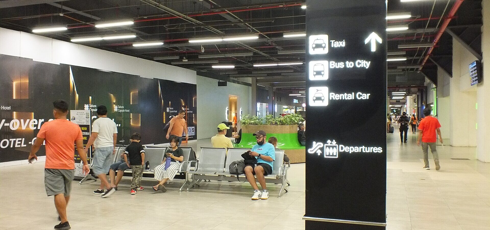 Arrivals area at Mactan-Cebu International Airport with signs to the taxi, the bus to the city and rental cars