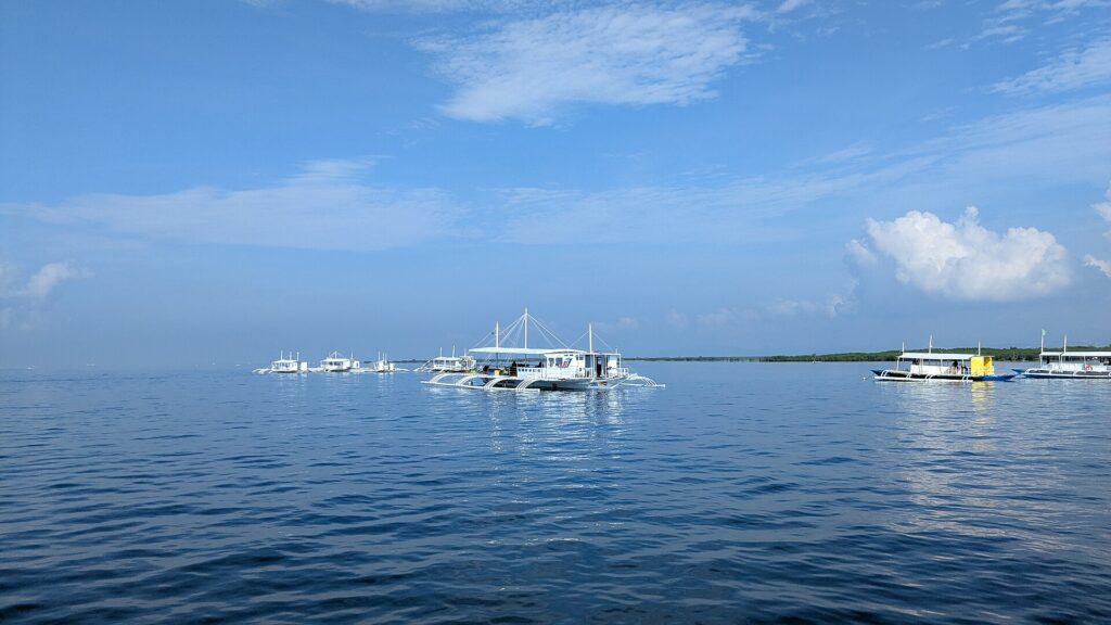 Island-hopping bangkas waiting on calm blue water off Lapu-Lapu