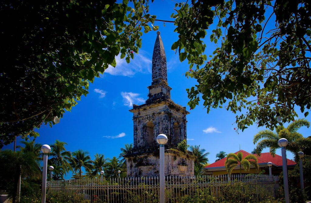 The coral-stone Magellan Monument from 1866, framed by trees