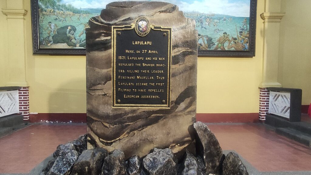 The marker for Lapulapu's victory of 27 April 1521, with a battle painting behind
