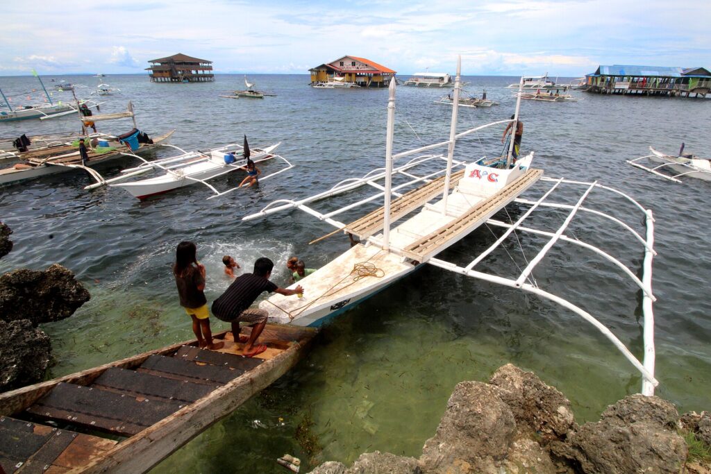 Bangkas tied up at Caw-oy, with floating huts offshore