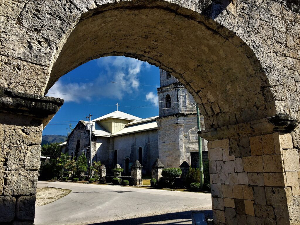 Oslob Church framed by a coral-stone arch of the Cuartel