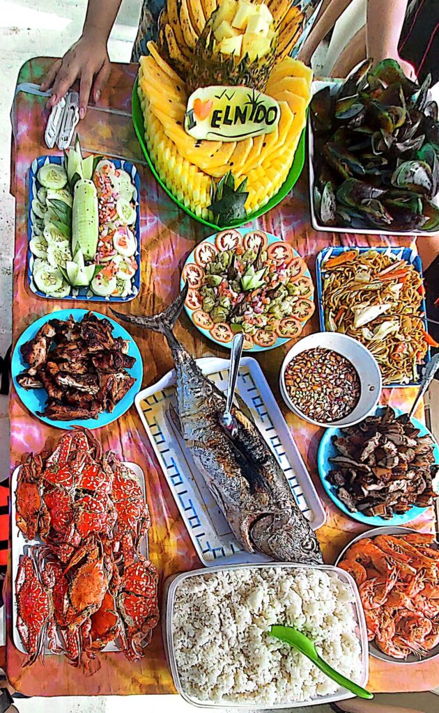 A boodle-fight lunch of grilled seafood and fruit on an El Nido island tour