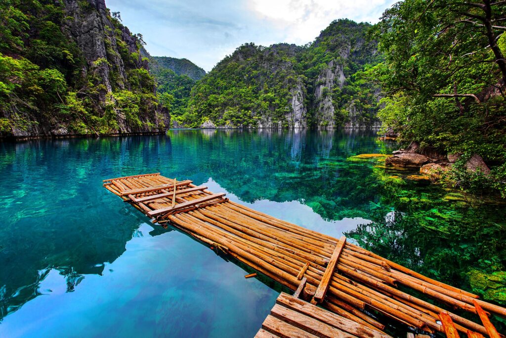 Glass-clear water and a bamboo raft at Kayangan Lake, Coron Island