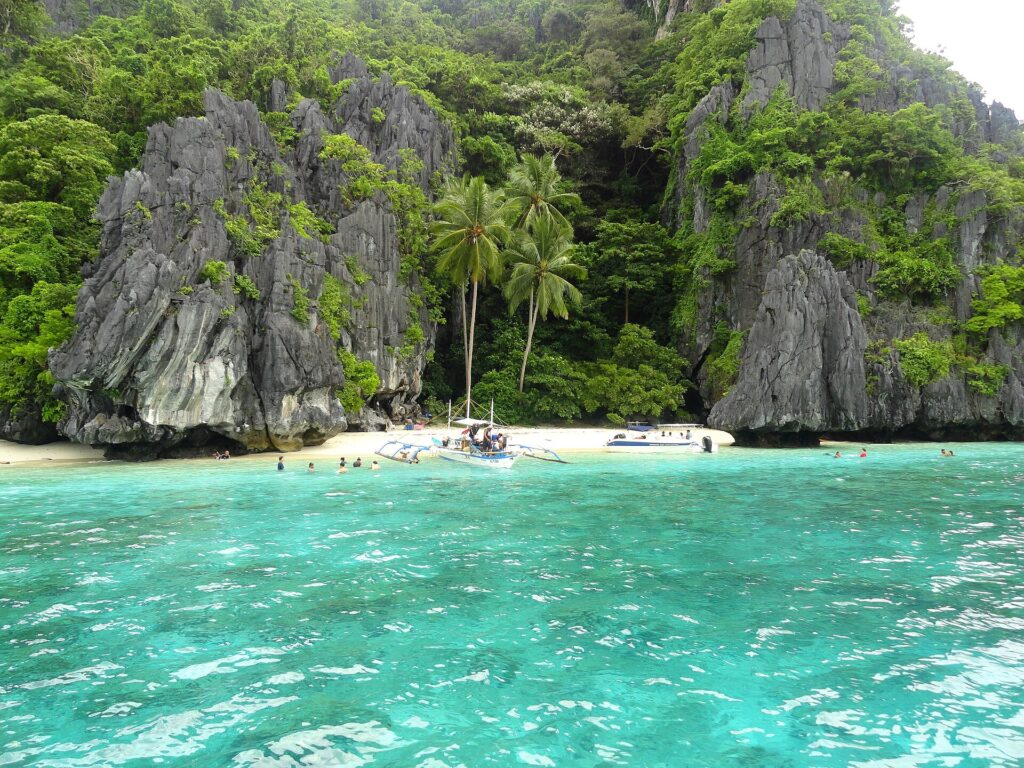 White sand and turquoise shallows below the cliffs of Entalula Island