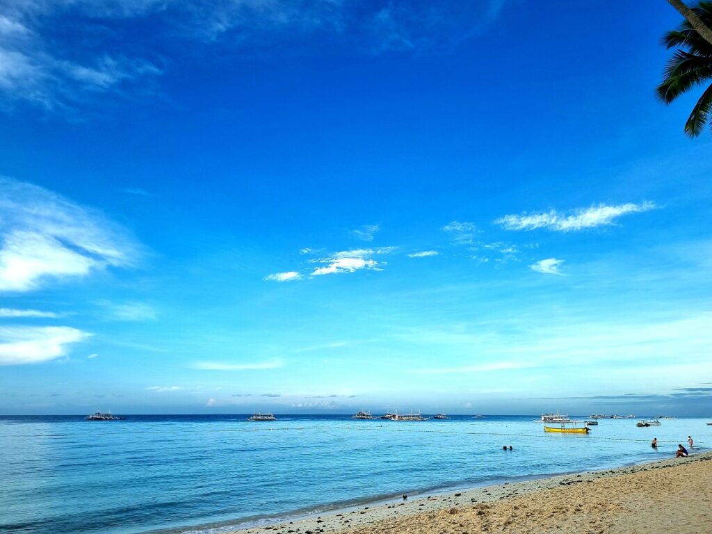 Calm blue water and white sand at Alona Beach
