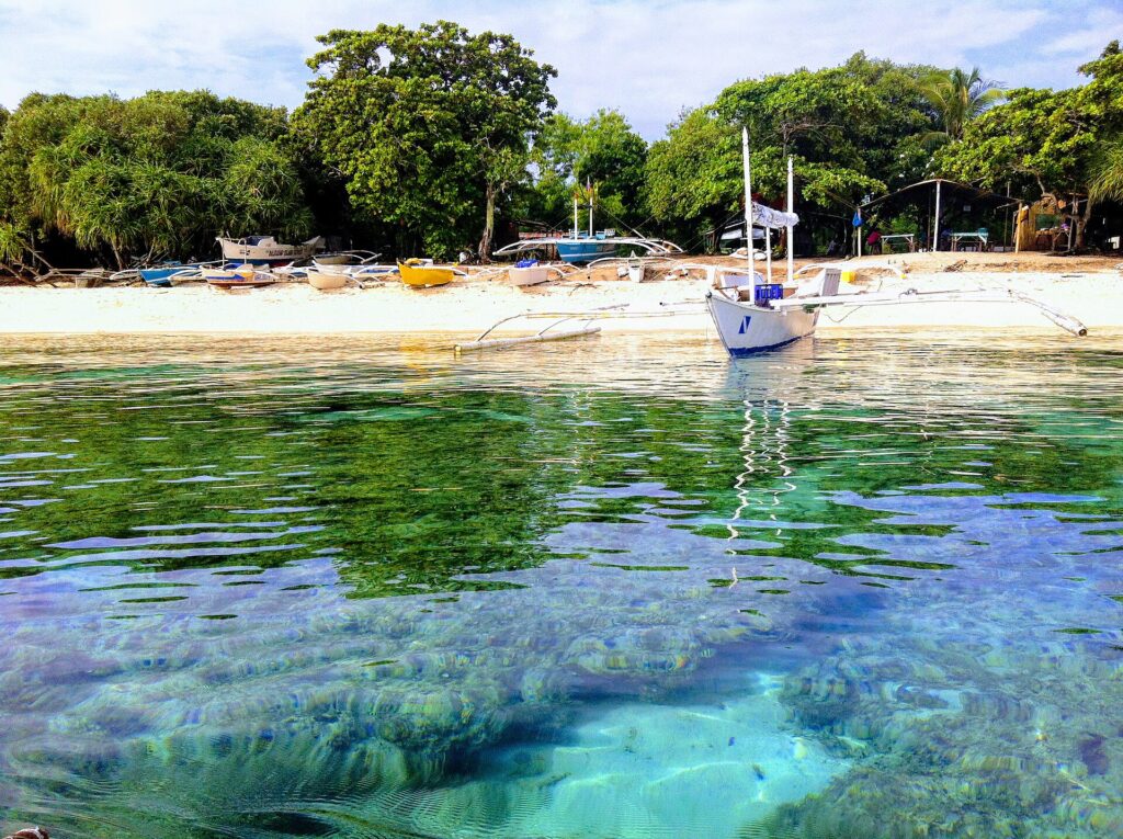 Crystal-clear shallows and outrigger boats at Balicasag Island
