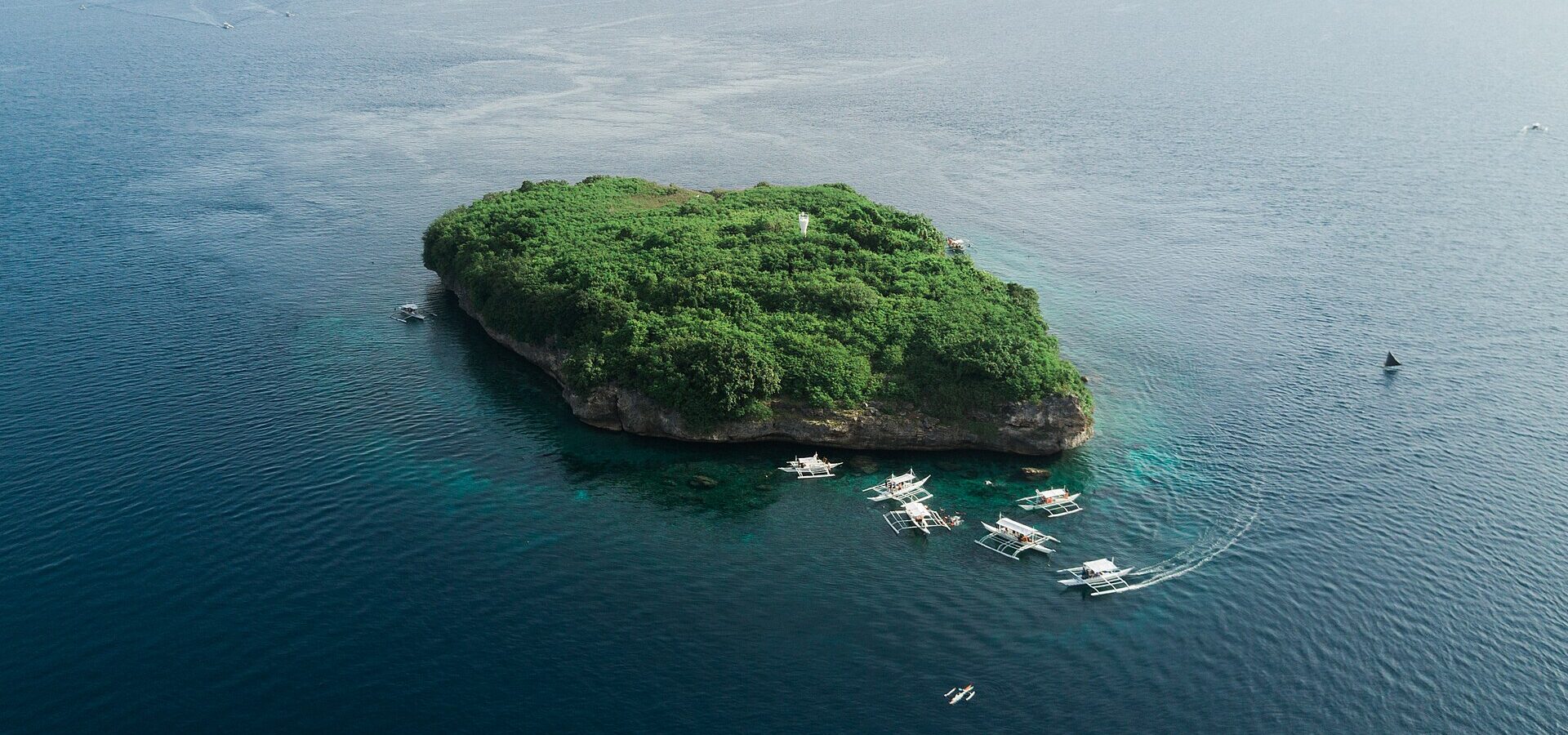 Pescador Island off Moalboal, a small green island rising from the clear blue sea