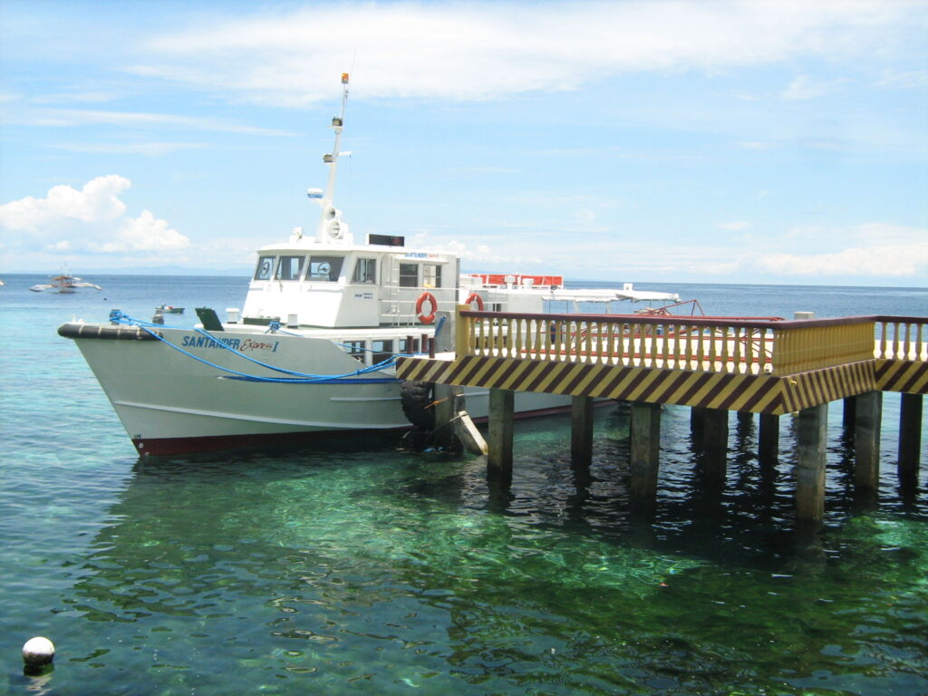 A fast craft at the Liloan port jetty in Santander, over clear turquoise water
