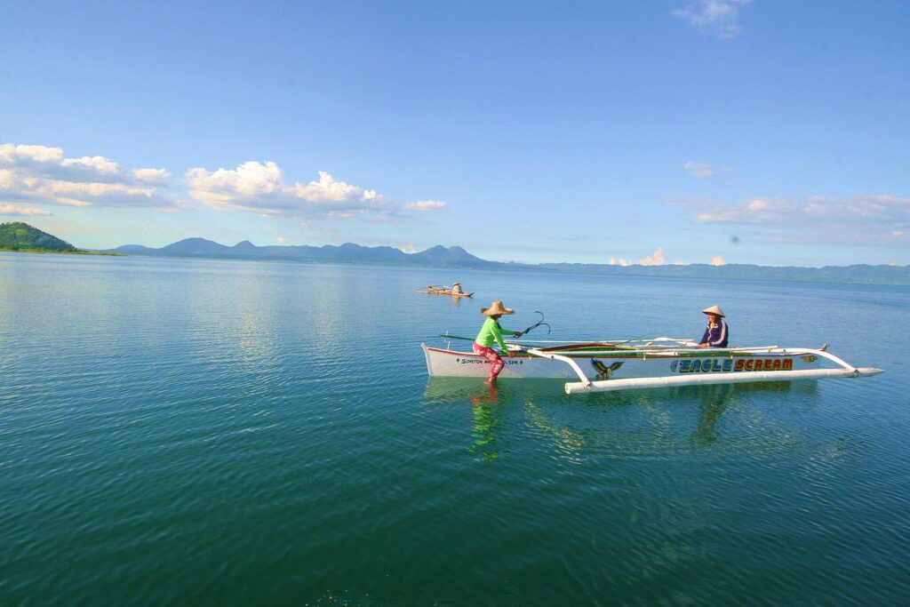 A local fisherman paddling an outrigger on calm morning water