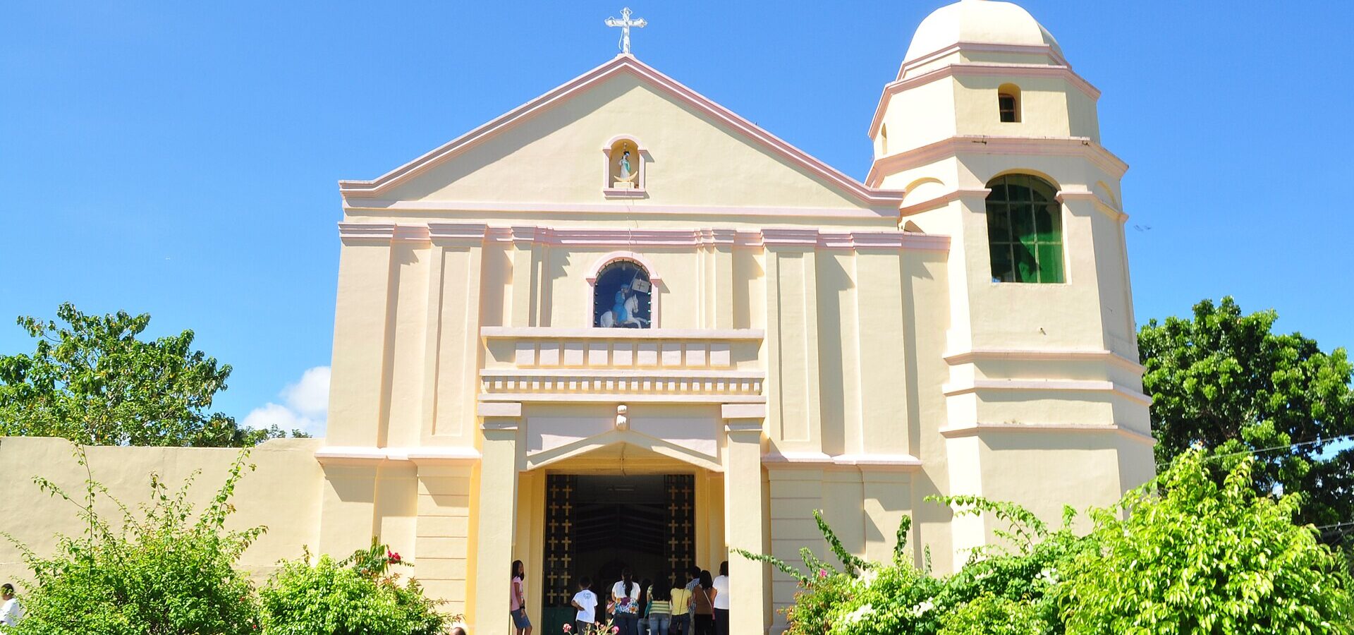 The cream facade and domed bell tower of St. James the Apostle Parish Church in Sogod, under a blue sky