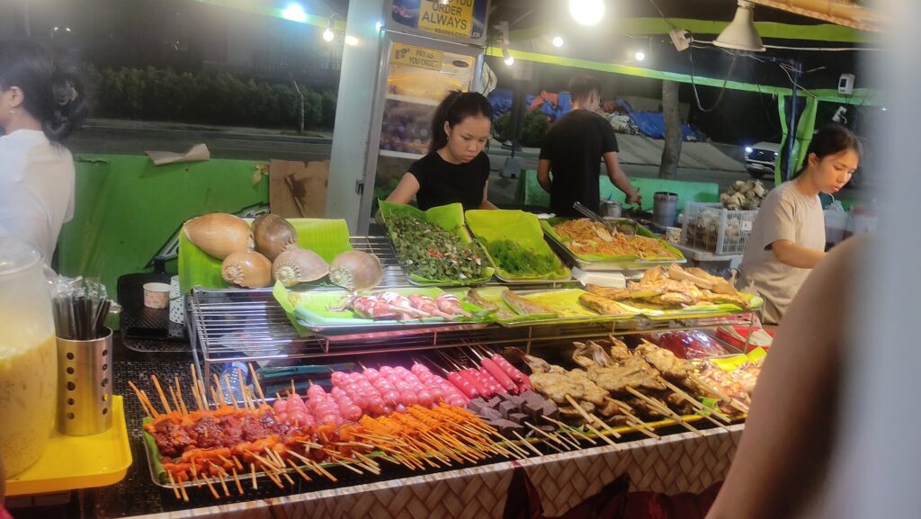 A night food stall with rows of marinated skewers ready for the grill in Cebu
