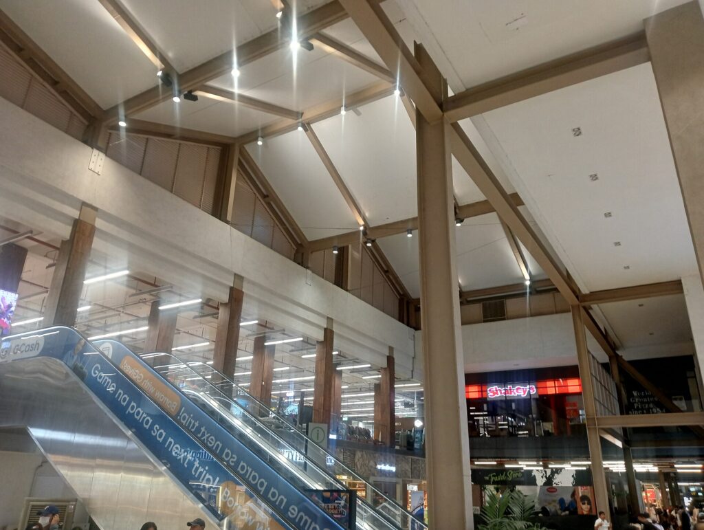 The high wooden-beamed ceiling and escalators inside Mactan-Cebu International Airport Terminal 1