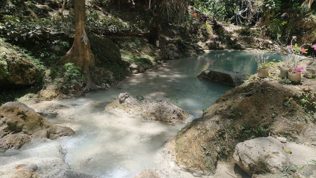 Clear water running between rocks below the falls